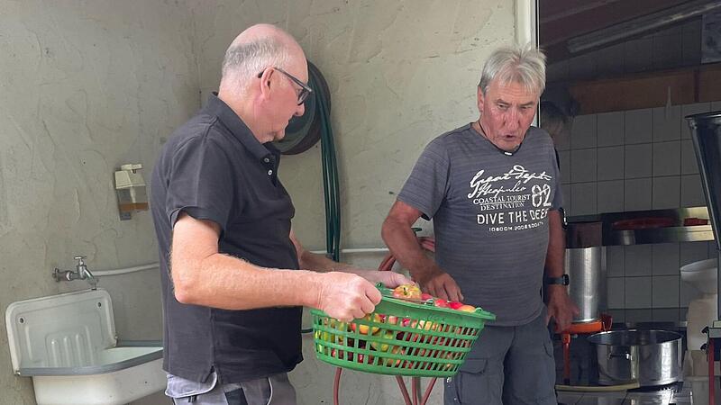 Heinz Rumpel (links) und Willi Hüttner vom Obst- und Gartenbauverein Neubrunn bereiten die Äpfel für die Kelter vor.