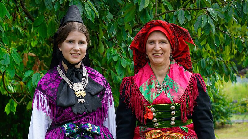 Das Buch &bdquo;Evangelische Trachten in der Fr&auml;nkischen Schweiz&ldquo; zeigt zwei Trachten aus der Region: Links eine typisch evangelische schwarz-lila Tracht, rechts eine farbenfrohe katholische Tracht &ndash; ein Gegensatz, der lange als typisch galt.