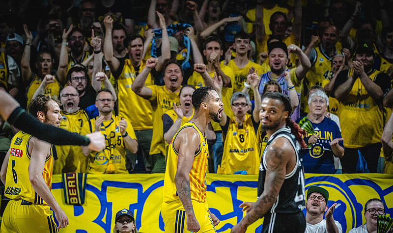 Norris Agbakoko jubelt nach einem Korbleger plus Foulpfiff, der Bamberger Cobe Williams (im Vordergrund) ist bedient.