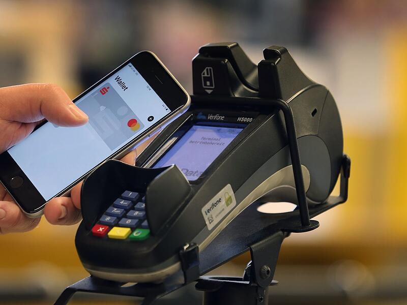 Smartphone zum Bezahlen an der Kasse eines Supermarkts Smartphone zum Bezahlen an der Kasse eines Supermarkts