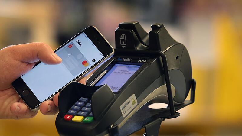 Smartphone zum Bezahlen an der Kasse eines Supermarkts Smartphone zum Bezahlen an der Kasse eines Supermarkts