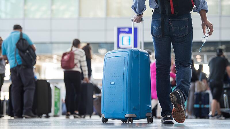 Ein Passagier geht mit einem Koffer Flughafen