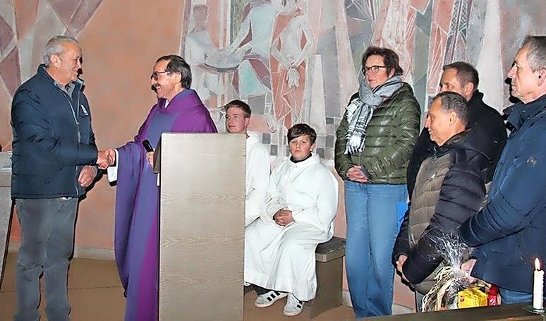 Pfarrer Walter Ries bedankte sich mit einem H&auml;ndedruck bei Heinrich Leicht. Weiter auf dem Bild die Mitglieder der Kirchenverwaltung und Ministranten. Aus den H&auml;nden der Kirchenverwaltung erhielt Heinrich Leicht eine Urkunde und einen Geschenkkorb.