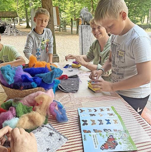 Die Mischung aus Naturerleben vor Ort und Spaß an kreativem Umsetzen gefällt den Kindern – hier Filzen von Schmetterlingen mit Eva Friedrich im Wildpark Klaushof.