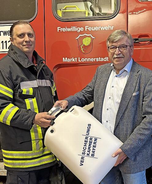 Helmut Roppelt (rechts) &uuml;bergibt Martin Kolb, Zweiter Kommandant der Freiwilligen Feuerwehr Lonnerstadt, den Schwimmsauger.