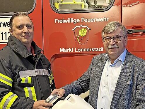 Helmut Roppelt (rechts) &uuml;bergibt Martin Kolb, Zweiter Kommandant der Freiwilligen Feuerwehr Lonnerstadt, den Schwimmsauger.