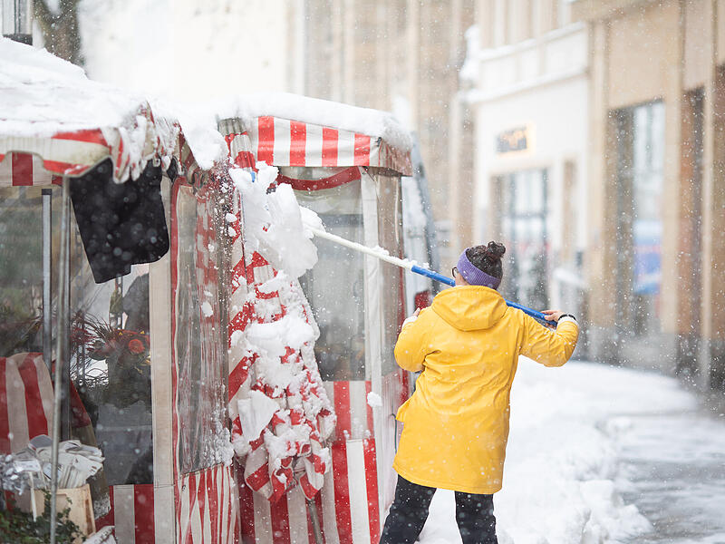 Die H&auml;ndler am Gr&uuml;nen Markt befreien ihre St&auml;nde vom Schnee.