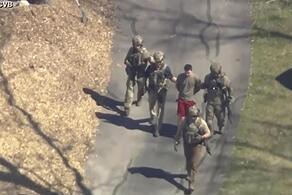 Dieses Bild aus einem von WCVB-TV zur Verf&uuml;gung gestellten Video zeigt den 21-J&auml;hrigen in T-Shirt und Shorts, der von bewaffneten Einsatzkr&auml;ften in Gewahrsam genommen wird.