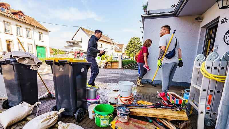 Anwohner r&auml;umen eine vom Hochwasser betroffenen Erdgeschoss-Wohnung im Saarland aus.