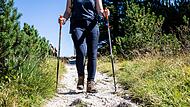 Eine Wanderin unterwegs mit Wanderst&ouml;cken