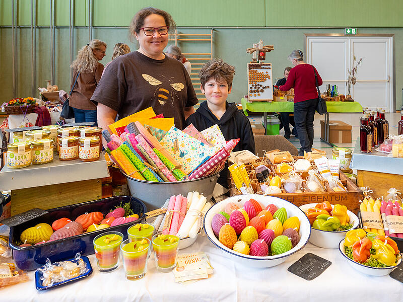 Die Imkerin Sonja Weber aus Hetzles pr&auml;sentiert bei ihrer ersten Teilnahme am Marktplatz des Landfrauentags in Heroldsbach gemeinsam mit ihrem Sohn Honig, Bienenwachskerzen und Bienenwachst&uuml;cher.