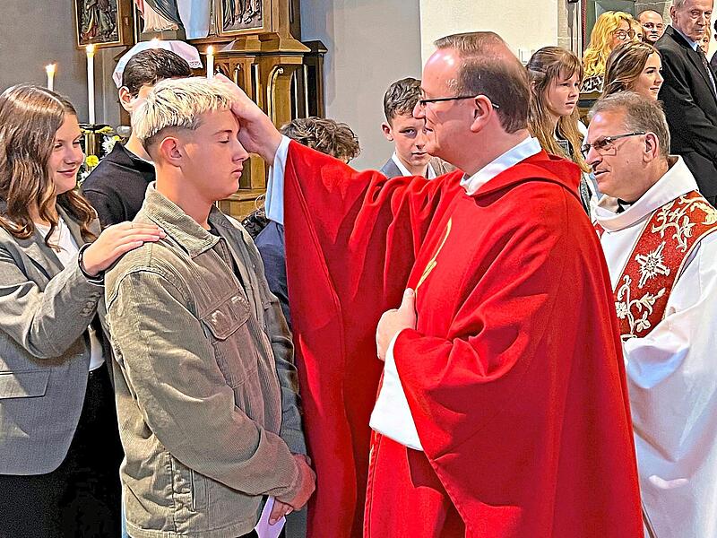 Albert Müller erteilt hier das Sakrament der Firmung an Vincent Hauck; rechts im Bild ist Pfarrer Richard Reis zu sehen.Susanne Deuerling Albert Müller erteilt hier das Sakrament der Firmung an Vincent Hauck; rechts im Bild ist Pfarrer Richard Reis zu sehen.Susanne Deuerling