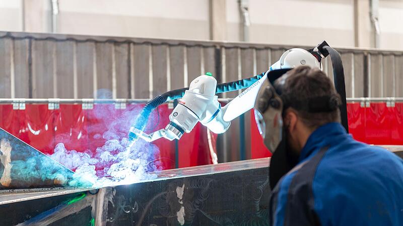 Mensch und Roboter arbeiten bei der Produktion der Weiden aus Stahl in &Ouml;sterreich zusammen.