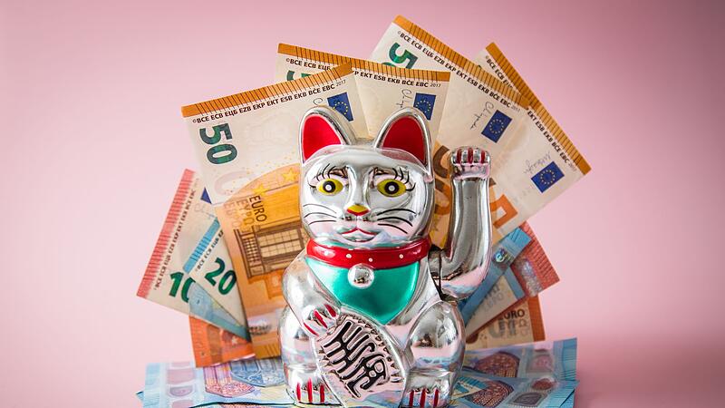 Japanische Glückskatze Maneki-neko mit Geldscheinen