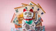 Japanische Glückskatze Maneki-neko mit Geldscheinen