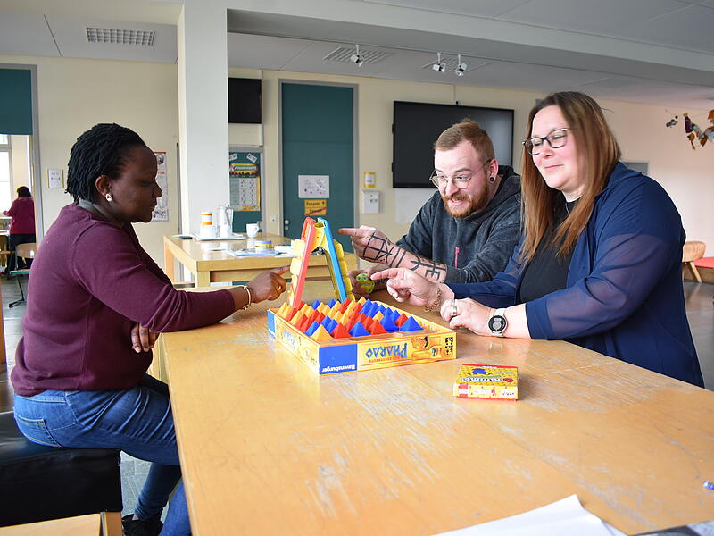 Florence R&ouml;ck (l.), Nico Sch&uuml;tz und Yvonne Simon t&uuml;fteln in der Mittelschule in Gr&auml;fenberg an einem Spiel.