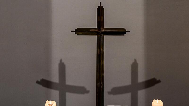 Brennende Kerzen und Kreuz