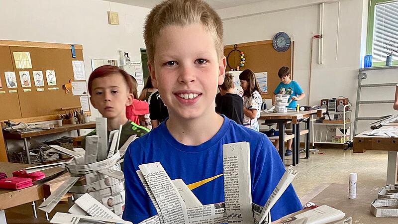 Grundschüler aus Vierreth-Trunstadt stellen Körbe aus gelesenen Zeitungen her.