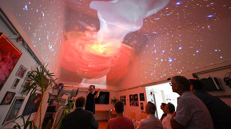 Frank Fleischmann erkl&auml;rt Besuchern, was die beiden neuen Projektoren an die Decke gerade projiziert haben: ein schwarzes Loch.Forchheim & Fr&auml;nkische Schweiz