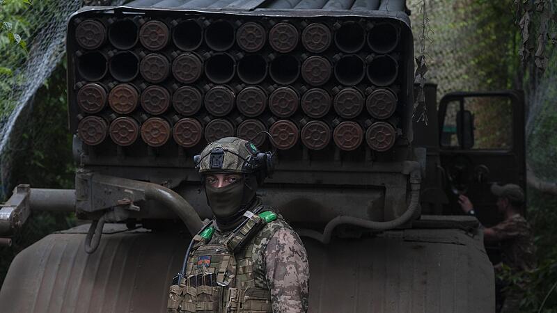 Ein ukrainischer Soldat steht neben einem Mehrfachraketenwerfersystem an der Frontlinie in der Region Donezk.