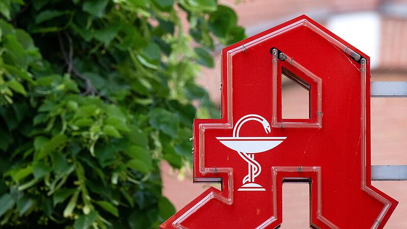 Das Logo einer Apotheke hängt an einem Gebäude in  Bayern.