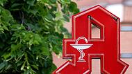 Das Logo einer Apotheke hängt an einem Gebäude in  Bayern.