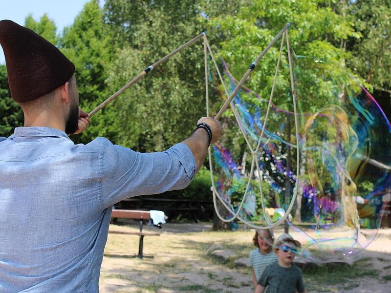 Seifenblasen werden möglichst groß aufgeblasen bei Swing im Park in Neustadt bei Coburg.