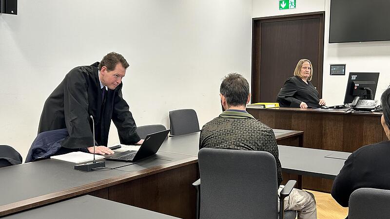 Der Angeklagte spricht mit seinem Verteidiger (l.). Er soll eine Matratze in einem Flüchtlingsheim in Erlangen angezündet haben.