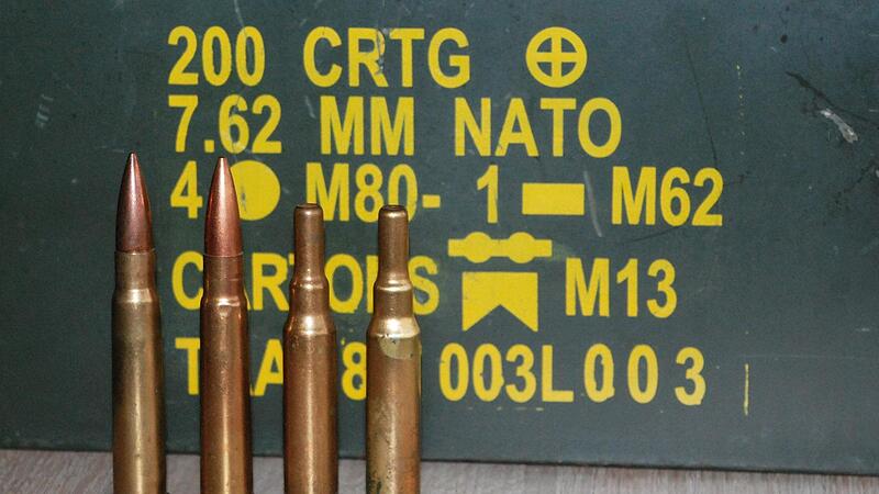 Dekomunition unter anderem im Kaliber .303 british vor einer Munitionskiste mit weiteren Spezifikationen: Hier finden 200 Patronen im alten Nato Kaliber 7,62 mm Platz.