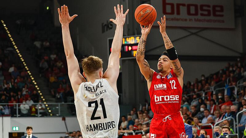 Bambergs Justin Robinson (rechts) setzt zum Wurf gegen den Hamburger Justus Hollatz an. Der Brose-Aufbauspieler war von der Stimmung in der Arena nach dem Sieg begeistert.