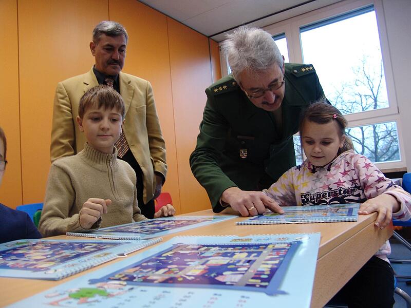 c_polizeikalender2 Dezember 2008: Die Kinder erläutern dem damaligen Polizeichef Udo Skrypczak und Rektor Axel Meyer ihr Bild, das bei einem Malwettbewerb für einen Kalender ausgewählt wurde.