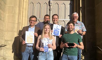 Freuen sich &uuml;ber die neuen Prozessionshefte und pr&auml;sentieren Cover und Hefte und die digitale Version (v.l.): B&uuml;rgermeister Jens Korn, Kirchenpfleger Jan Regel, Nicole Wei&szlig;, Pfarrer Detlef P&ouml;tzl, Thomas Wei&szlig; und Franz Behrschmidt.