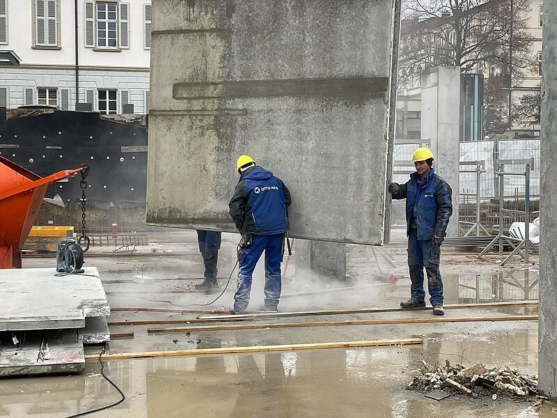 Der Riesenkran hebt eine Fertigteilwand an Ort und Stelle.