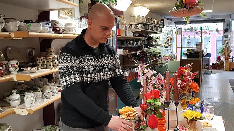 „Wühlkisten“-Mitarbeiter Stefan Schmidt dekoriert einen Verkaufstisch im Eberner Laden.