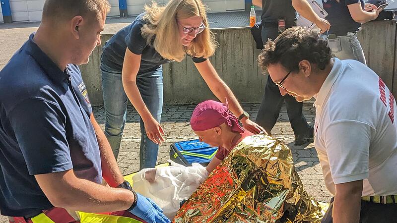 Lehrgangsleiterin Natascha Below (Mitte) überprüft die fachgerechte Versorgung einer Verbrühung am Arm des „Unfallopfers“.