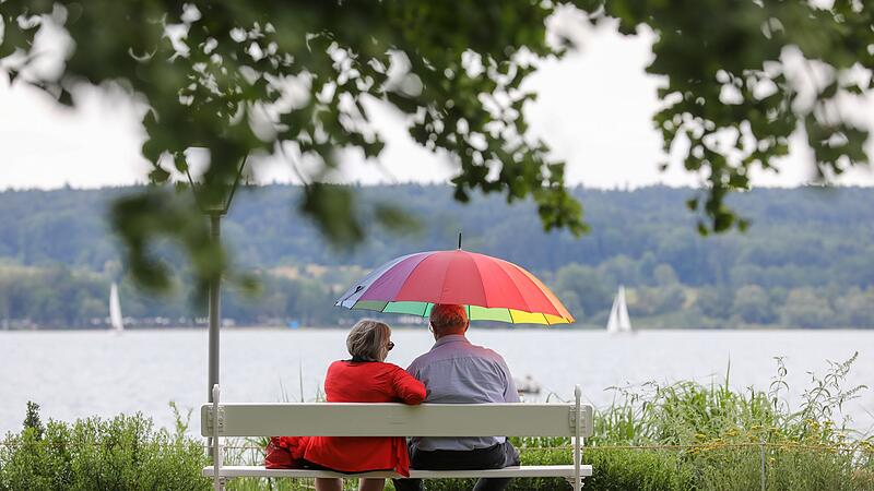 Renter sitzen mit einem Schirm am See