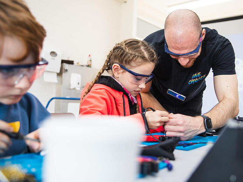 Hier ist Fingerspitzengef&uuml;hl gefragt. Betreuer Niklas L&ouml;ffler unterst&uuml;tzt die Kinder bei ihrem Projekt.