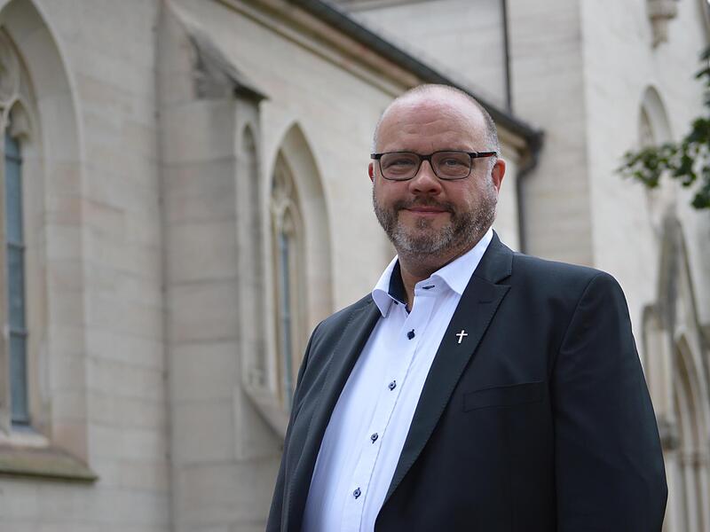 Pfarrer Gerd Greier vor der Stadtpfarrkirche in Bad Kissingen.