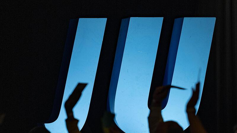 Delegierte heben auf einer Landesversammlung der Jungen Union vor dem Logo der JU ihre Stimmkarten.