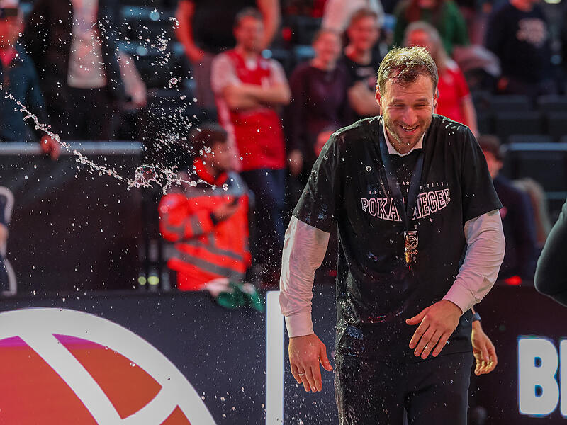 Mit einem verschmitzten Lächeln im Gesicht, versucht der Bamberger Coach Anton Gavel der Wasserdusche auf dem Parkett zu entkommen. Mit einem verschmitzten Lächeln versucht der Bamberger Coach Anton Gavel der Wasserdusche auf dem Parkett zu entkommen.