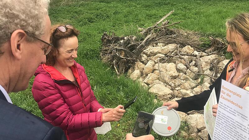 B&uuml;rgermeister German Hacker und Umweltbeauftragte Monika Preinl zeigen wie Geocaching funktioniert: Am besten mit dem Smartphone. Und Klimabeauftragte Mignon Ramsbeck-Ullmann zeigt, wie dann der Fund aussehen sollte.