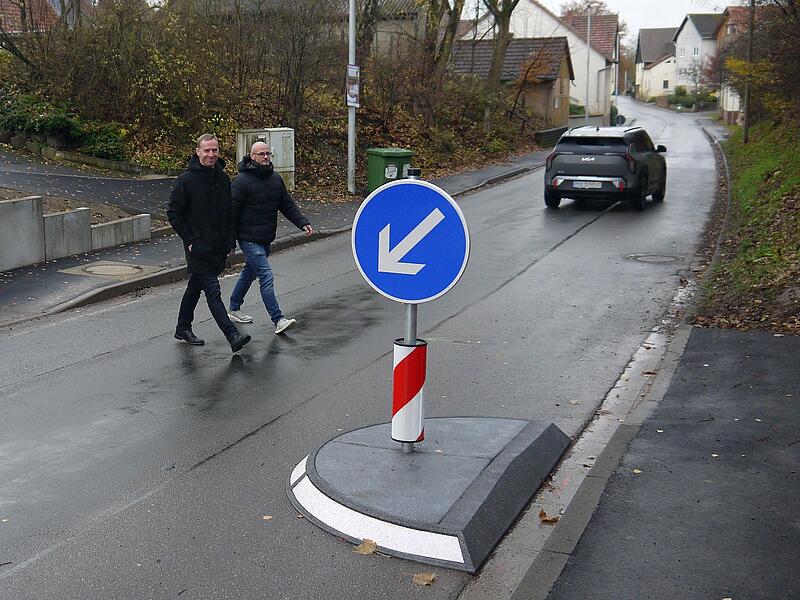 Als würde der Pfeil zeigen, wo es für Fußgänger langgeht: Bernd Höfer (links) und Patrick Härter freuen sich, dass Fußgänger in Beuerfeld sicherer als bisher die Kreisstraße CO 17 überqueren können.