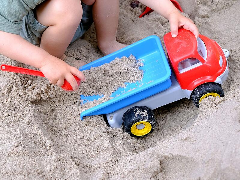 Kleinkind spielt im Sandkasten