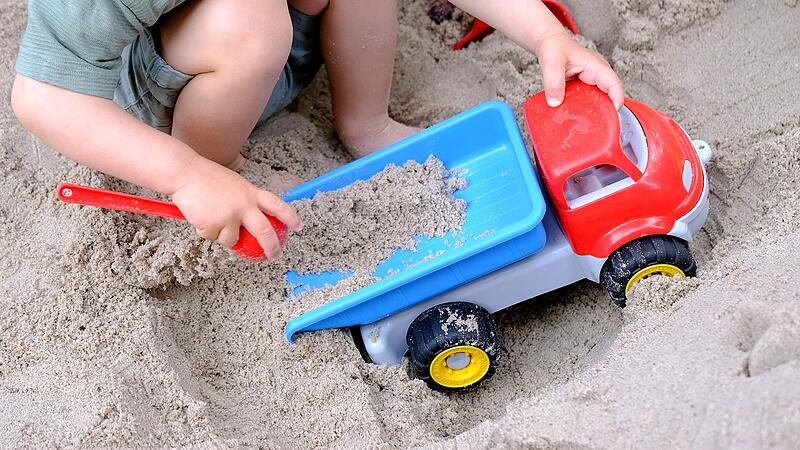 Kleinkind spielt im Sandkasten Kleinkind spielt im Sandkasten