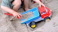 Kleinkind spielt im Sandkasten Kleinkind spielt im Sandkasten