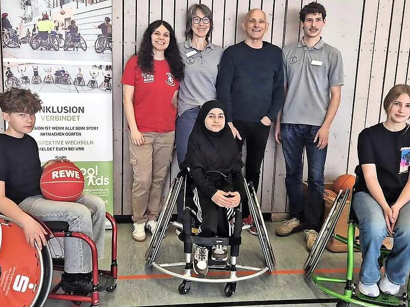 Bei der &Uuml;bergabe des Sportrollstuhls freute sich Amira (Mitte) sehr, weil sie nun sportlich aktiver sein kann.