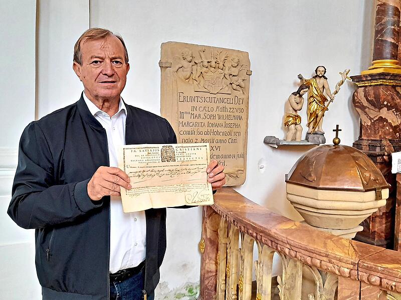 Kirchenführer Oswald Purucker zeigt ein Echtheitszertifikat aus dem Jahre 1791, dessen Geheimnis er nach vielen Jahren mit Hilfe von künstlicher Intelligenz auf seinem Handy aufklärte. Dahinter ist die Grabsteininschrift (Epitaph) der Bayreuther H... Kirchenführer Oswald Purucker zeigt ein Echtheitszertifikat aus dem Jahre 1791, dessen Geheimnis er nach vielen Jahren mit Hilfe von künstlicher Intelligenz auf seinem Handy aufklärte. Dahinter ist die Grabsteininschrift (Epitaph) der Bayreuther H...