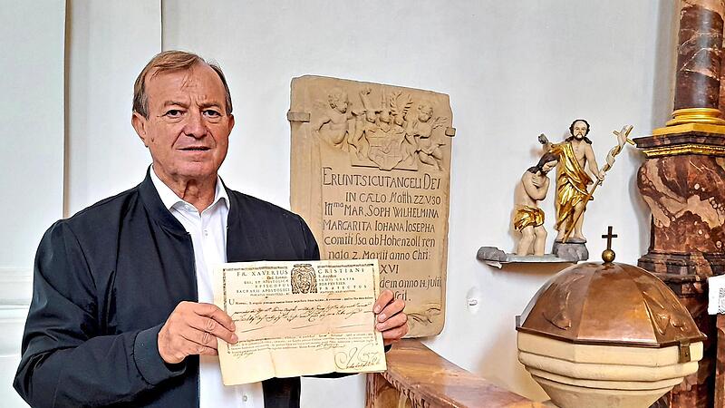 Kirchenführer Oswald Purucker zeigt ein Echtheitszertifikat aus dem Jahre 1791, dessen Geheimnis er nach vielen Jahren mit Hilfe von künstlicher Intelligenz auf seinem Handy aufklärte. Dahinter ist die Grabsteininschrift (Epitaph) der Bayreuther H... Kirchenführer Oswald Purucker zeigt ein Echtheitszertifikat aus dem Jahre 1791, dessen Geheimnis er nach vielen Jahren mit Hilfe von künstlicher Intelligenz auf seinem Handy aufklärte. Dahinter ist die Grabsteininschrift (Epitaph) der Bayreuther H...