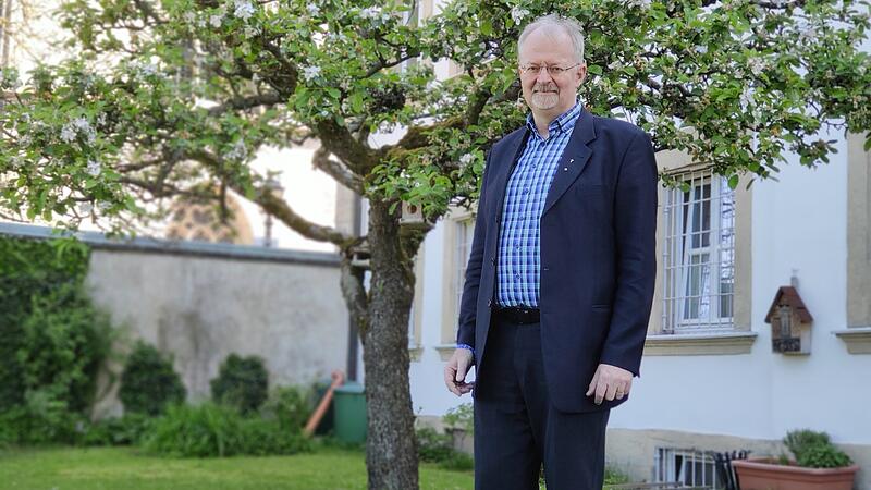 Thomas Teuchgräber steht im Pfarrhausgarten hinter der St. Johannes-Kriche.