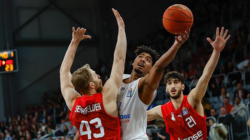 Der Wei&szlig;enfelser Kostja Mushidi setzt sich unter dem Korb gegen Brose-Kapit&auml;n Christian Sengfelder durch; rechts der Bamberger Center Gabriel Chachashvili.